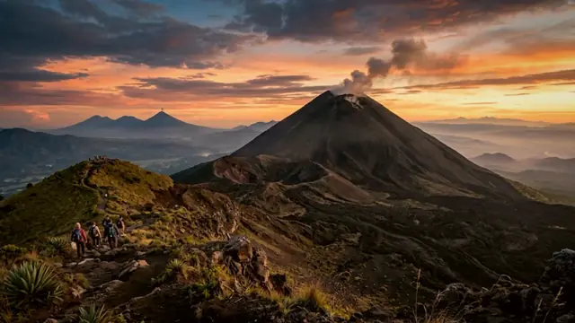 Senderistas en la cresta del Volcán Pacaya al amanecer, con el cono humeante al fondo